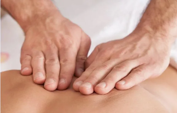 Practitioner performing myofascial release on a client's upper back